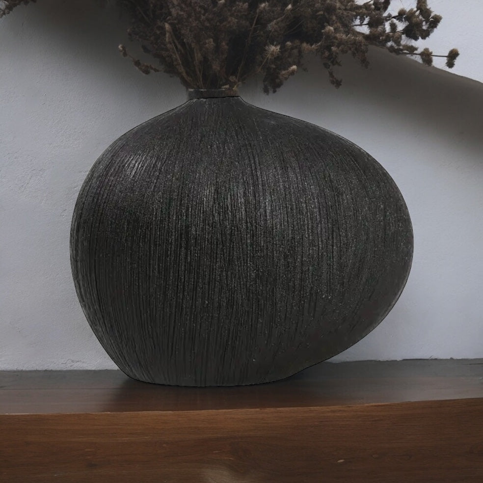 front of teardrop vase with dark dried flowers